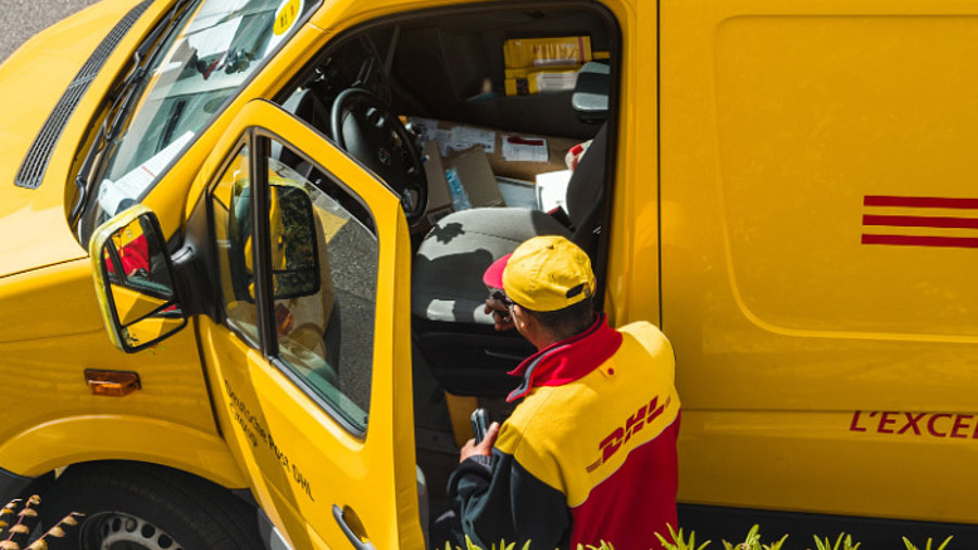 DHL Zusteller und Wagen