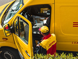 DHL Zusteller und Wagen