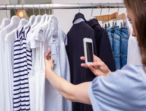 Frau fotografiert Preisschild in Mode-Geschäft