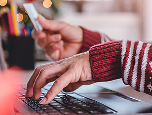 Frau im Weihnachtspulli shoppt online