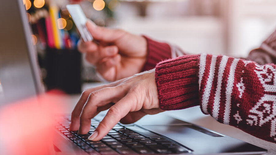 Frau im Weihnachtspulli shoppt online