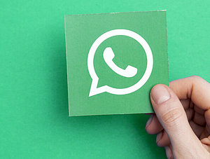 WhatsApp-Logo vor gr&uuml;ndem Hintergrund