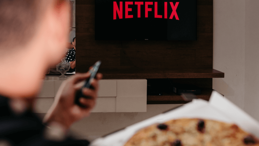 Mensch mit Pizza vor Netflix