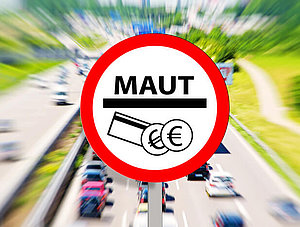 Mautschild mit Verkehr im Hintergrund