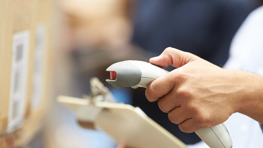 Mann mit Handscanner in Lager