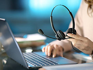 Callcenter Agent mit Laptop und Headset