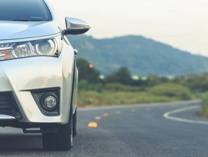 Auto von vorn, während es auf der Straße fährt.