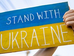 Hand h&auml;lt "Stand with Ukraine"-Plakat