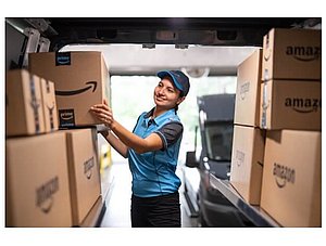 Amazon Logistiks Paketbotin im Lieferwagen