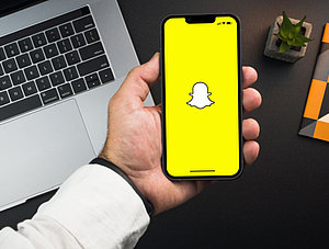 Mann hält Smartphone mit Snapchat