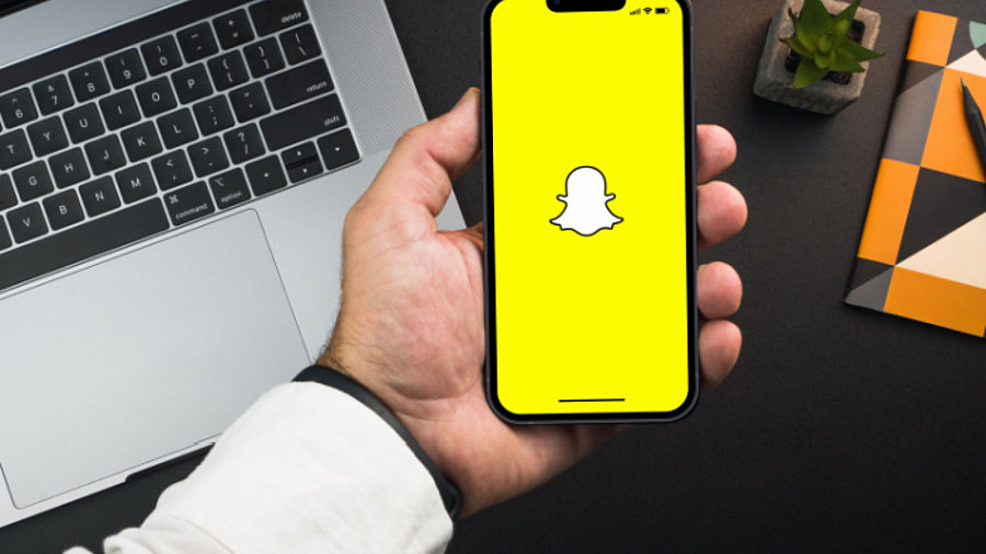 Mann hält Smartphone mit Snapchat