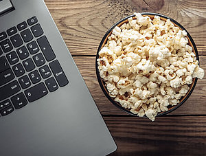 Streaming mit Freunden: Popcorn-Schüssel neben einem Laptop