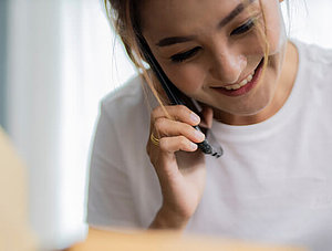 Frau am Telefon mit Paketen