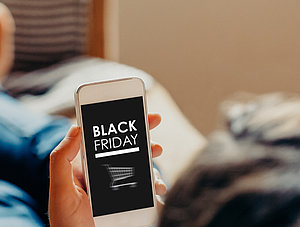 Mann mit Smartphone: Shoppen am Black Friday