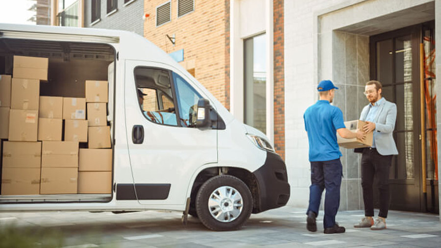 Paketübergabe Kurierdienst mit Lieferfahrzeug