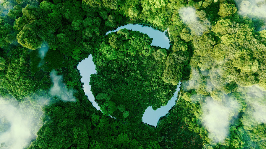 Gr&uuml;ne Landschaft, darauf Recyclingsymbol