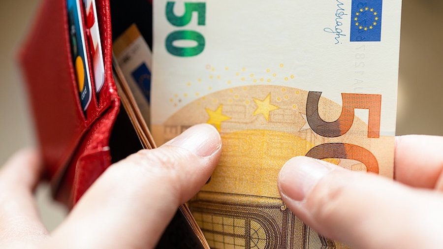 Person nimmt 50 Euro aus dem Portemonnaie