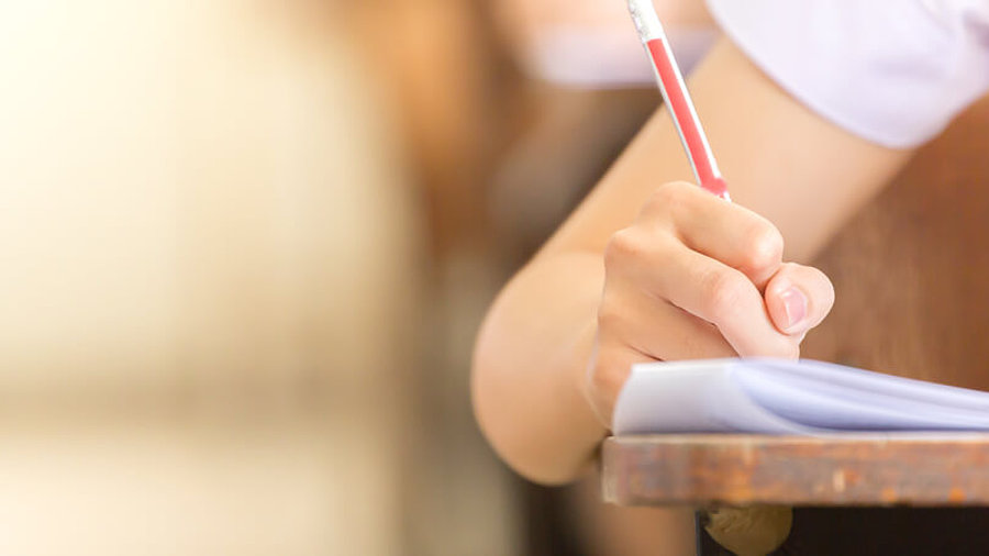 Sch&uuml;ler sitzt an Tisch