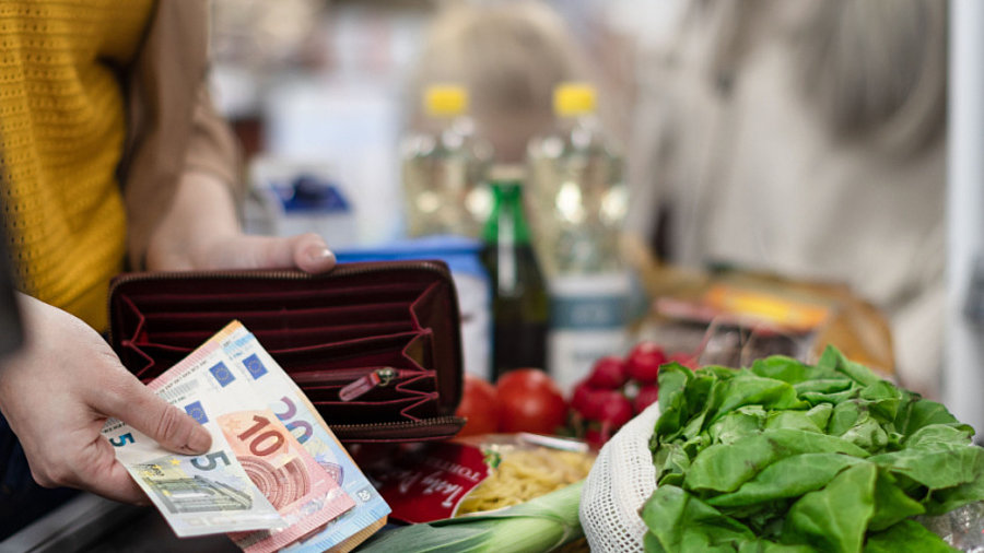 Frau bezahlt mit Euroscheinen an Supermarktkasse