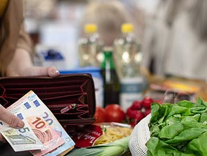 Frau bezahlt mit Euroscheinen an Supermarktkasse