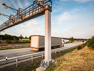 Lkw fährt unter Maut Station durch 