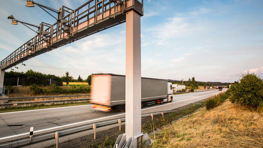 Lkw fährt unter Maut Station durch 