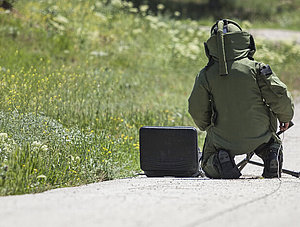 Mann mit Schutzanzug beim Bombe entschärfen