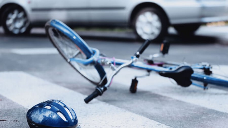 Fahrrad und Helm liegen auf der Straße.