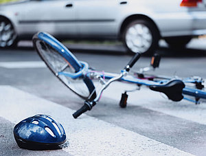 Fahrrad und Helm liegen auf der Straße.