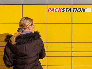 Frau vor einer Packstation