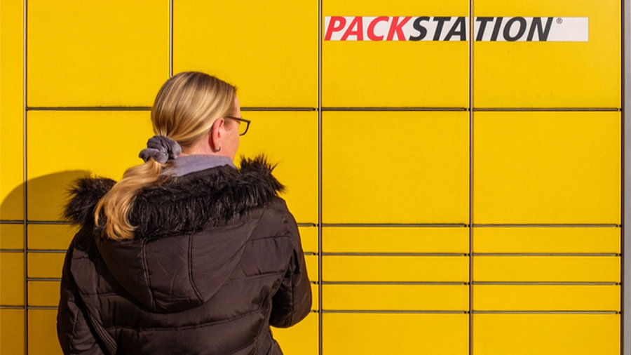 Frau vor einer Packstation