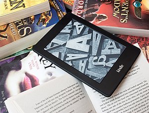 Amazon Kindle E-Book-Reader auf einem Haufen Bücher