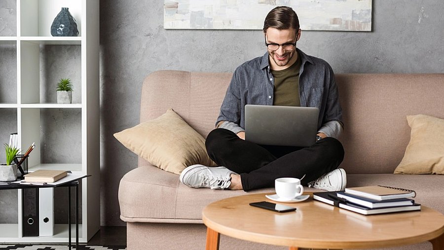 Mann arbeitet auf dem Sofa