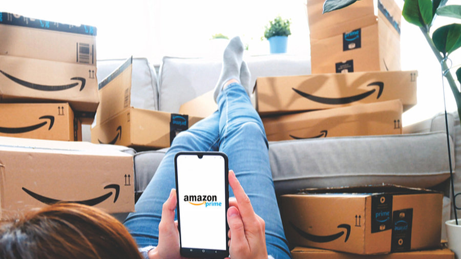 Frau liegt vor Sofa voller Amazon-Kartons