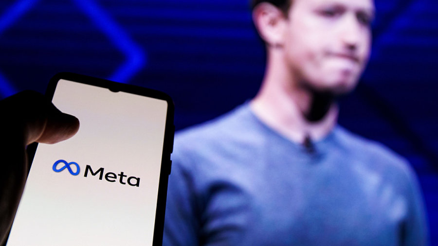 Smartphone mit Meta-Logo neben Mark Zuckerberg