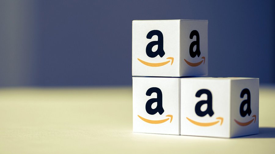 Kleine Pappkartons mit dem Amazon-Logo stehen übereinandergestapelt da