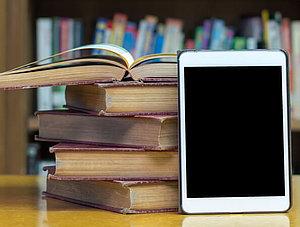 E-Book-Reader neben B&uuml;cherstabel