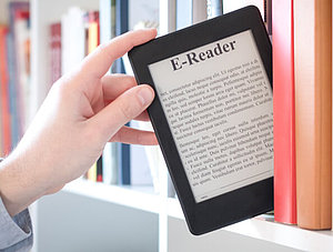 E-Book-Reader wird aus B&uuml;cherregal gezogen