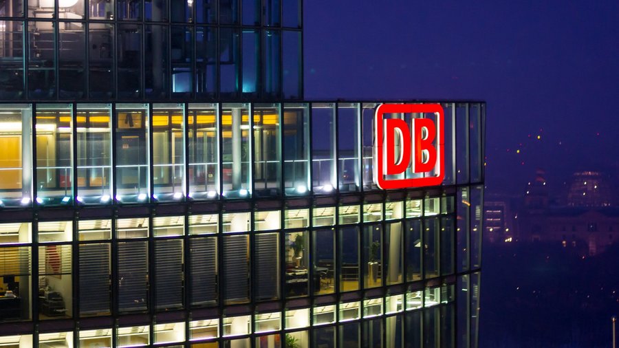 Deutsche Bahn Logo an Gebäude bei Nacht.