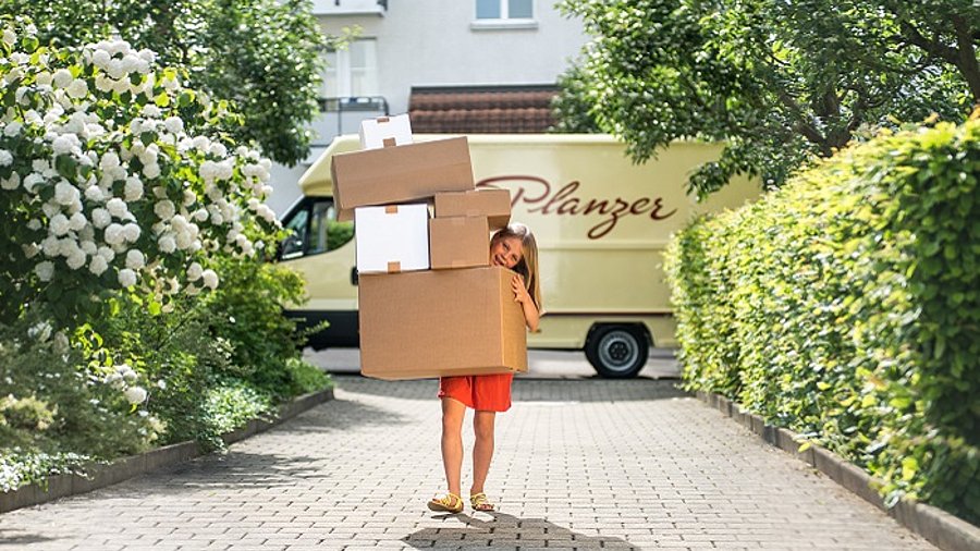 Kind mit Paketen, im Hintergrund Planzer Lieferwagen