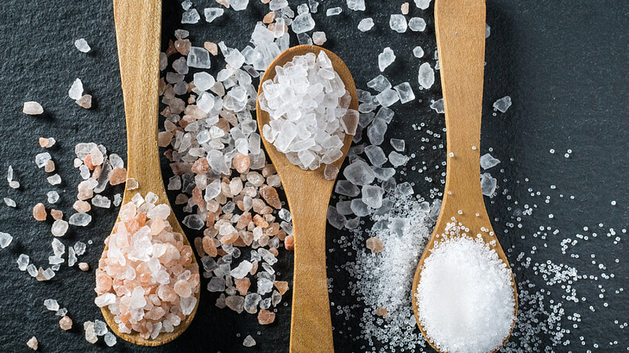 Verschiedene Arten von Salz auf Holzl&ouml;ffeln.