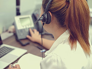 Frau mit Headset am Telefon