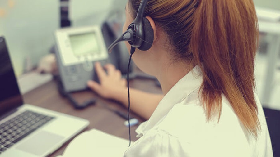 Frau mit Headset am Telefon