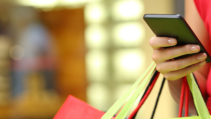 Frau beim Einkauf mit Smartphone