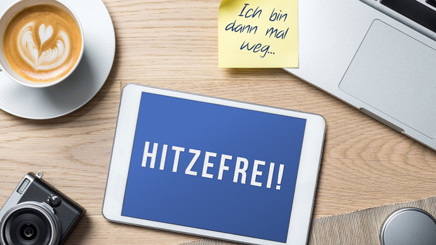 Utensilien im Homeoffice und Tablet mit Aufschrift Hitzefrei