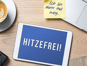 Utensilien im Homeoffice und Tablet mit Aufschrift Hitzefrei