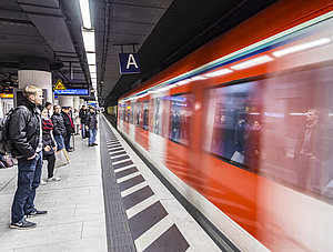 Menschen am Bahngleis warten bei Zugeinfahrt