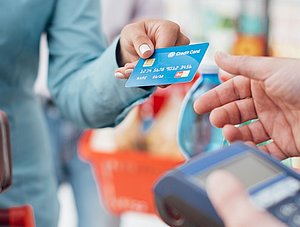 Frau bezahlt Einkauf an Supermarktkasse