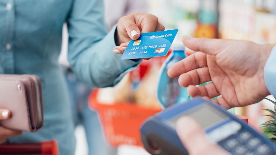 Frau bezahlt Einkauf an Supermarktkasse