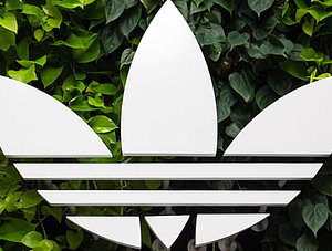 Adidas Logo auf gr&uuml;nem Hintergrund